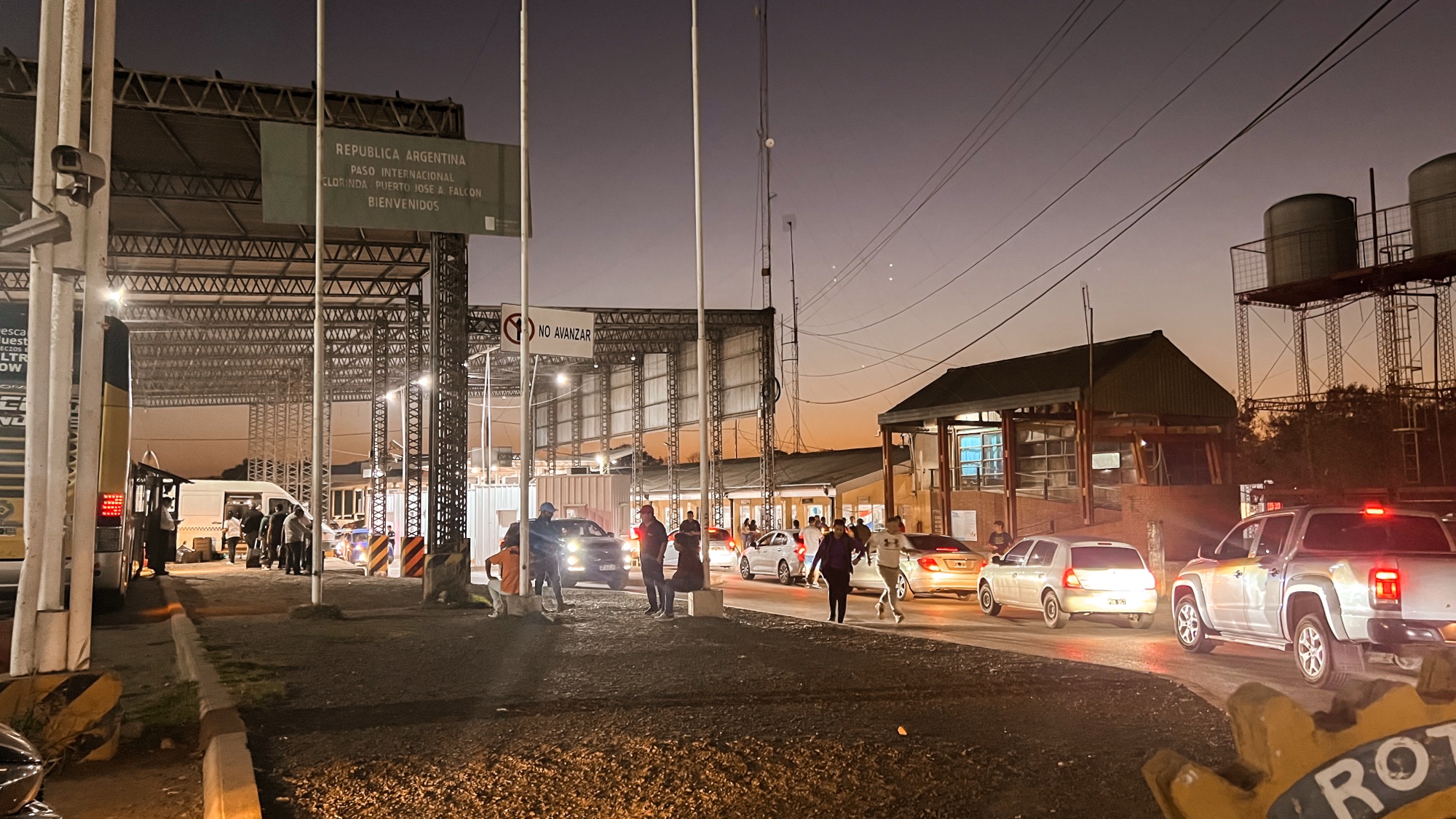 The Argentina/Paraguay bord crossing in Clorinda at sunset. There's a line of cars, people, and the migration building